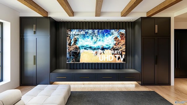 home theater room with light wood finished floors and beamed ceiling