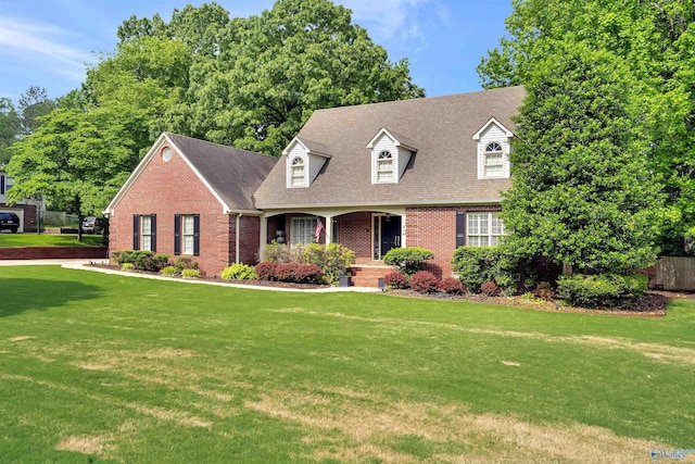 new england style home featuring a porch and a front yard