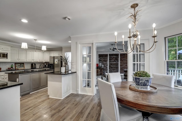 kitchen with crown molding, appliances with stainless steel finishes, pendant lighting, decorative backsplash, and white cabinets