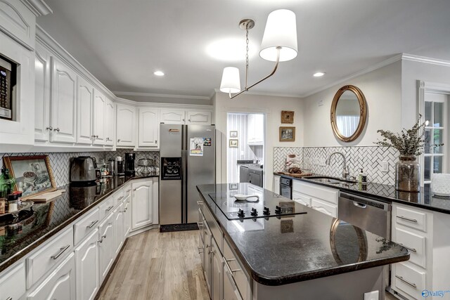 kitchen featuring a kitchen island, white cabinetry, appliances with stainless steel finishes, and washer and clothes dryer