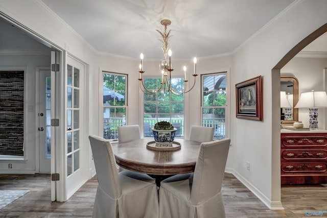 dining room with hardwood / wood-style floors, crown molding, and a chandelier