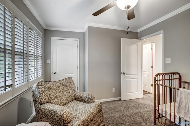 bedroom with crown molding, a nursery area, ceiling fan, and carpet