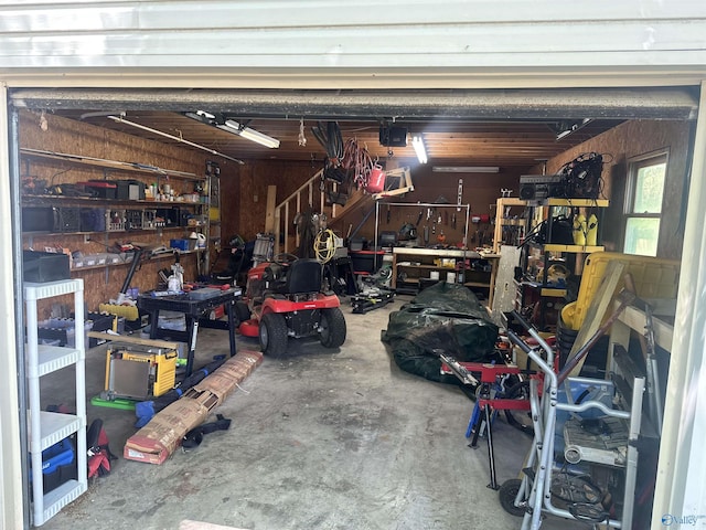 garage with wood walls and a workshop area