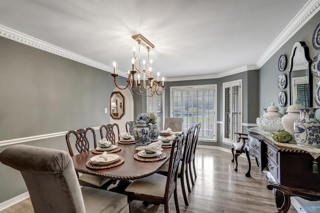 dining space featuring an inviting chandelier, ornamental molding, and light wood-type flooring