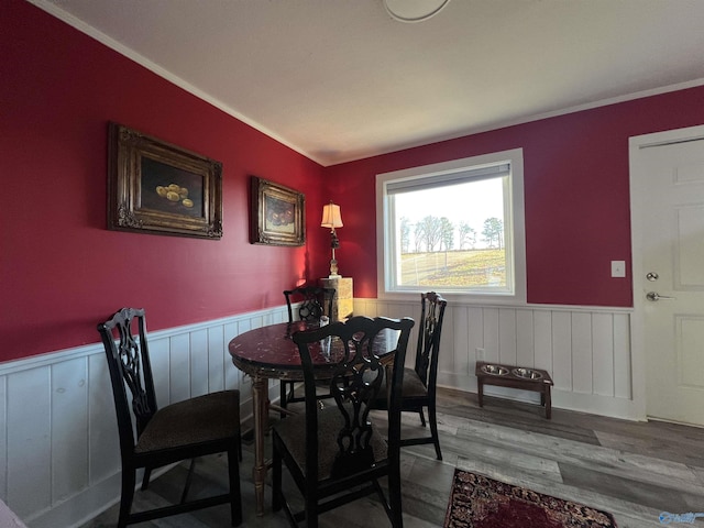 dining area with a wainscoted wall and wood finished floors