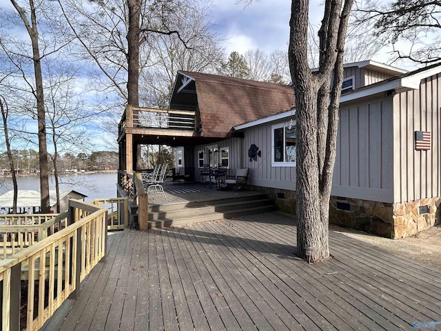 wooden terrace featuring outdoor dining area and a water view