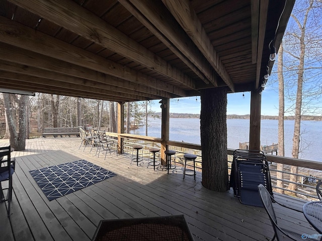 exterior space featuring exterior bar and a deck with water view