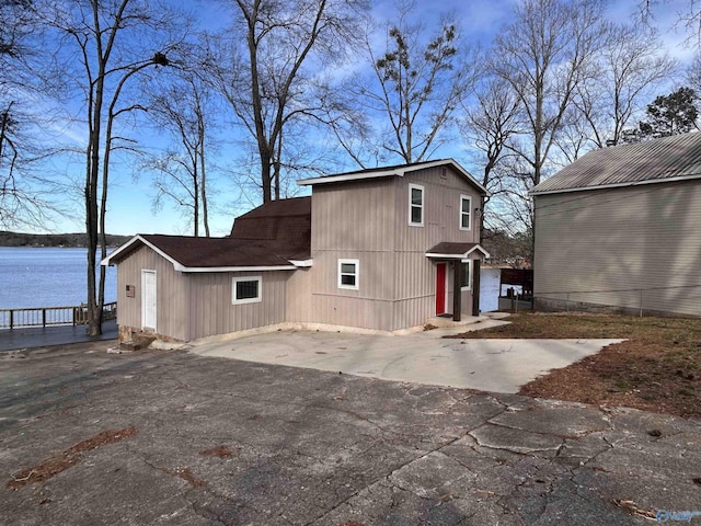 exterior space with a water view, a patio area, and driveway