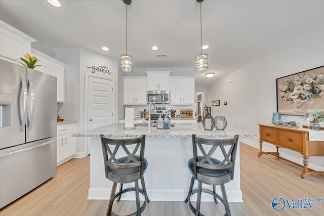 16604 Demi Dr, Athens, AL 35613 - kitchen with stainless steel appliances, light wood-type flooring, and white cabinetry