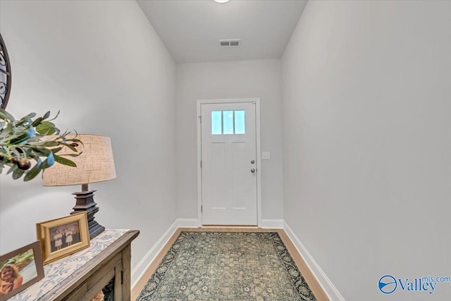 doorway with visible vents and baseboards