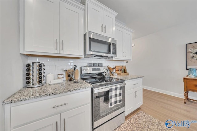 16604 Demi Dr, Athens, AL 35613 - kitchen with appliances with stainless steel finishes, backsplash, white cabinetry, and light wood-style floors