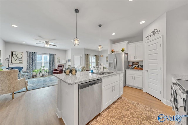 16604 Demi Dr, Athens, AL 35613 - kitchen with stainless steel appliances, a sink, white cabinets, open floor plan, and light wood finished floors