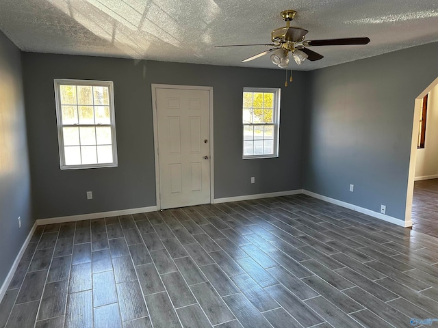 spare room with a healthy amount of sunlight, a textured ceiling, wood-type flooring, and ceiling fan