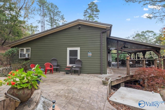 back of property featuring ceiling fan, a patio area, and a wooden deck