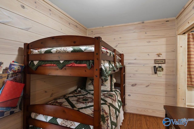 bedroom with wood walls and wood-type flooring