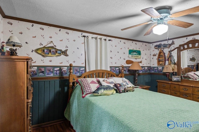 bedroom with a textured ceiling, hardwood / wood-style flooring, ceiling fan, and crown molding