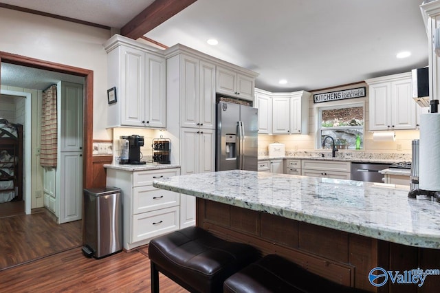 kitchen with white cabinetry, light stone counters, and appliances with stainless steel finishes