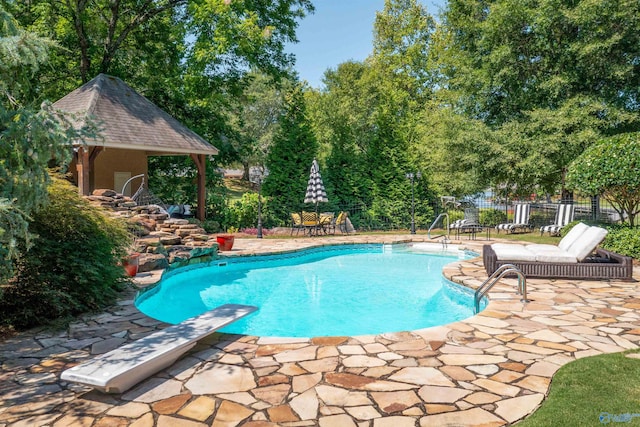 view of swimming pool featuring a diving board and a patio area