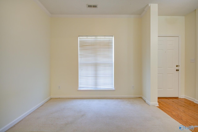 unfurnished room featuring ornamental molding and light carpet