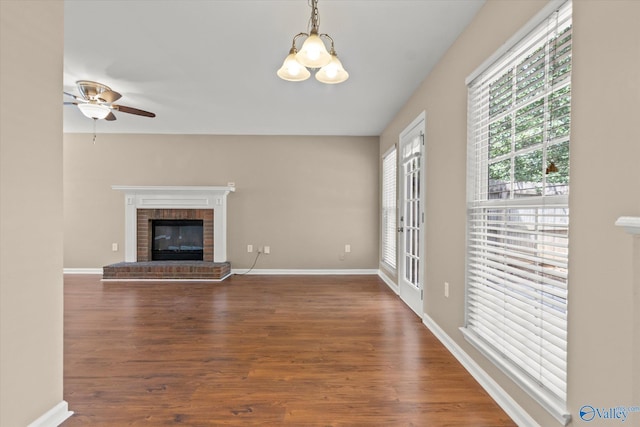 unfurnished living room featuring a fireplace, baseboards, and wood finished floors