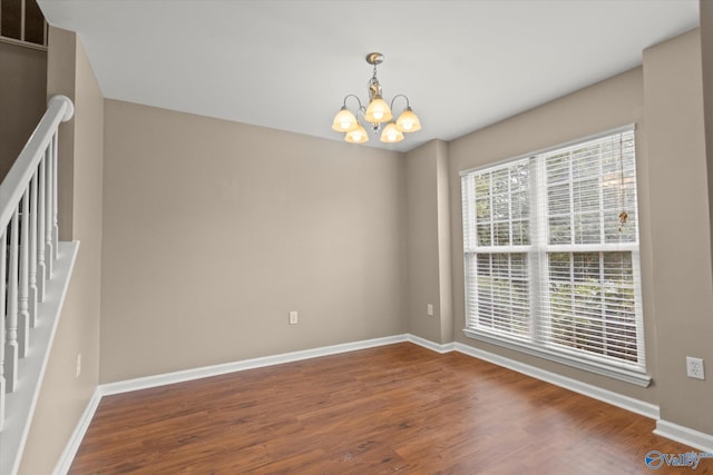 unfurnished room with wood finished floors, visible vents, and baseboards