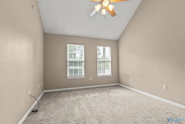 carpeted empty room with baseboards, visible vents, and vaulted ceiling