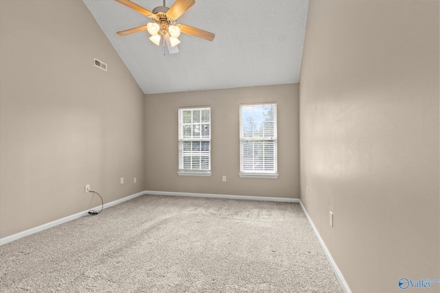 carpeted empty room featuring vaulted ceiling, ceiling fan, visible vents, and baseboards