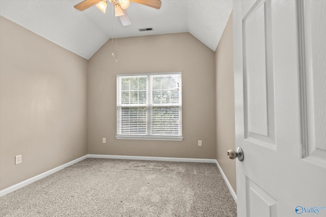 carpeted empty room with a ceiling fan, visible vents, vaulted ceiling, and baseboards