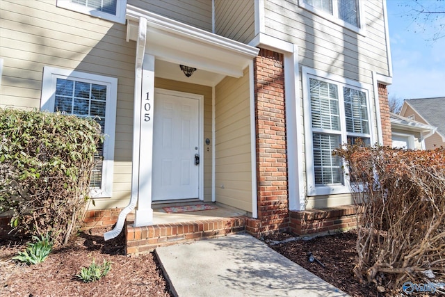 property entrance featuring brick siding