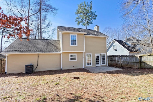 back of property with central AC unit, a patio, a chimney, roof with shingles, and fence