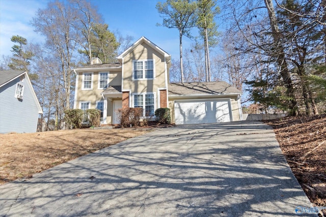 traditional-style house featuring an attached garage, driveway, a chimney, and brick siding