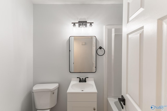 bathroom featuring a tub to relax in, vanity, and toilet