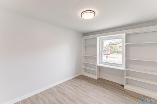 unfurnished room with baseboards and wood finished floors