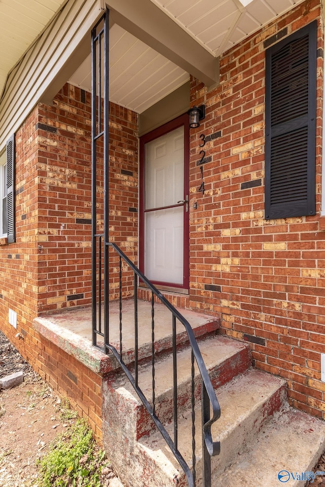 property entrance featuring crawl space and brick siding