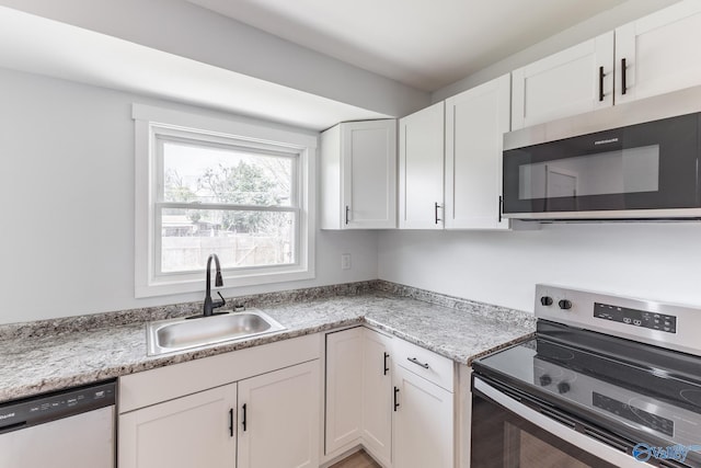 kitchen featuring white cabinets, appliances with stainless steel finishes, and a sink