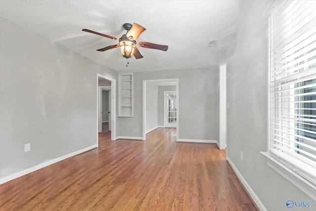 interior space with ceiling fan, a textured ceiling, and hardwood / wood-style flooring