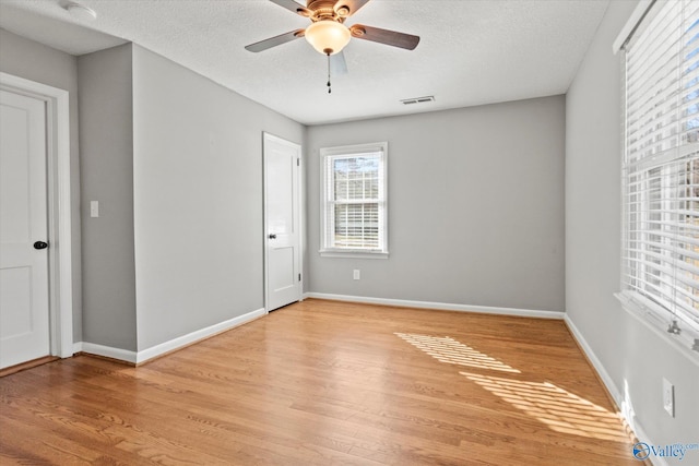 unfurnished bedroom with ceiling fan, light wood-type flooring, and a textured ceiling