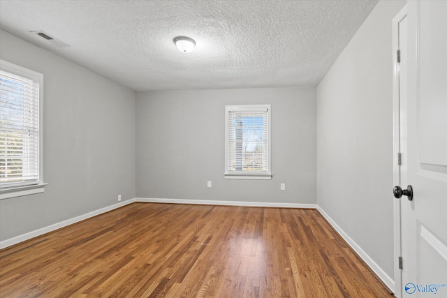 unfurnished room featuring a textured ceiling and hardwood / wood-style flooring