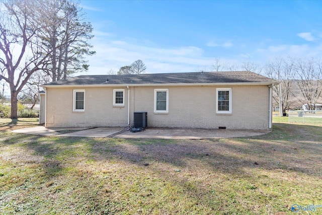 rear view of house with a lawn, cooling unit, and a patio area