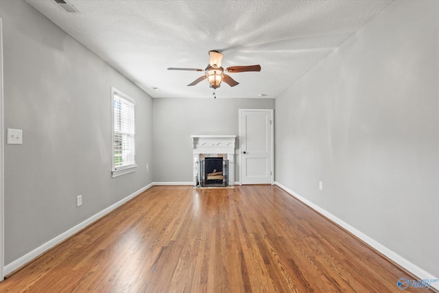 unfurnished living room with wood-type flooring, a textured ceiling, and ceiling fan