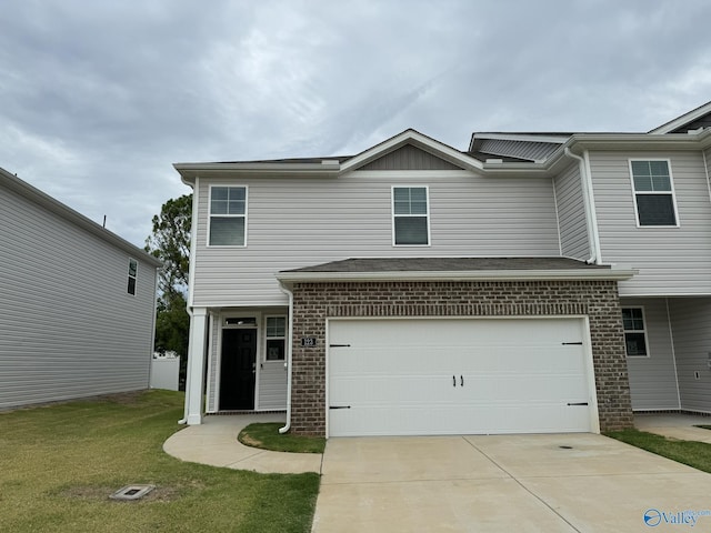 view of front of property featuring brick siding, a garage, concrete driveway, and a front yard