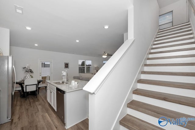 stairs with a ceiling fan, wood finished floors, and recessed lighting