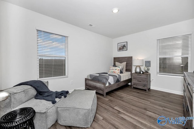 bedroom with dark wood finished floors and baseboards