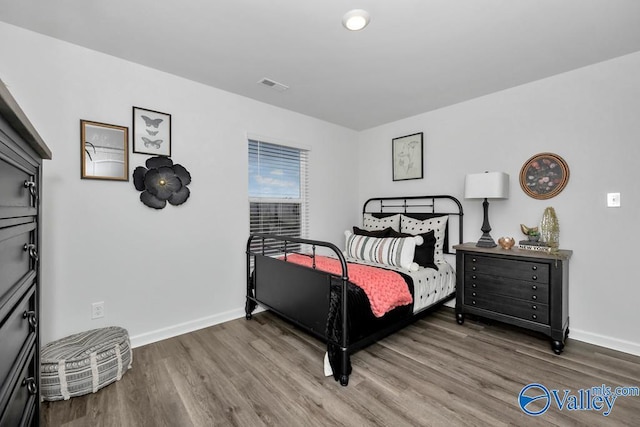 bedroom with wood finished floors and baseboards