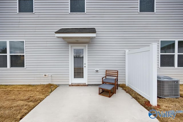 doorway to property featuring cooling unit, a patio, and a yard
