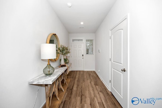 doorway featuring wood finished floors and baseboards