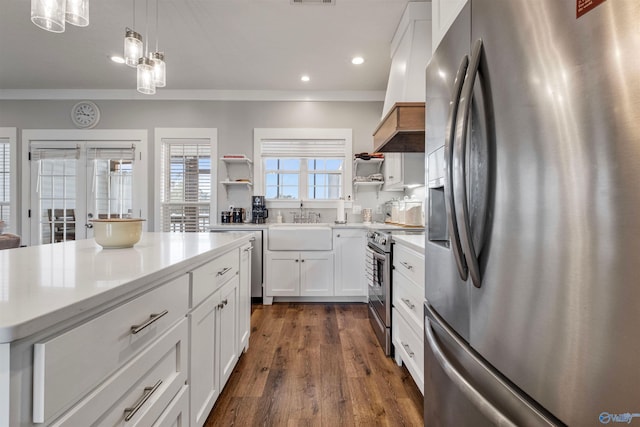 kitchen featuring white cabinetry, appliances with stainless steel finishes, dark hardwood / wood-style floors, custom exhaust hood, and pendant lighting