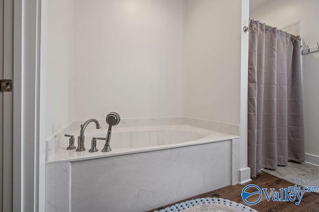 bathroom with hardwood / wood-style floors and a tub