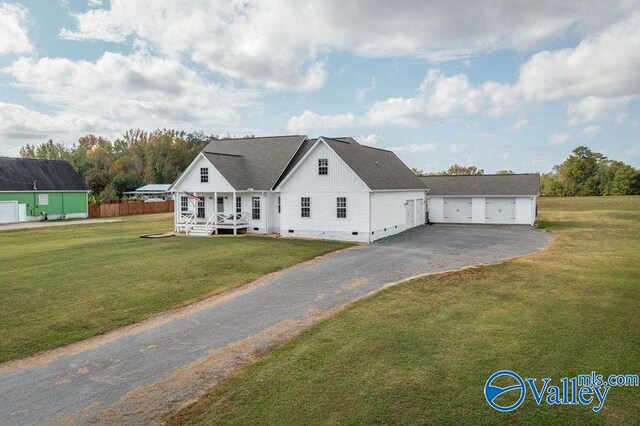 view of front facade with a garage, a porch, and a front lawn