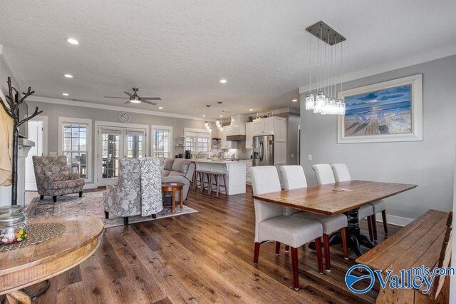 dining area featuring hardwood / wood-style floors, a textured ceiling, and crown molding